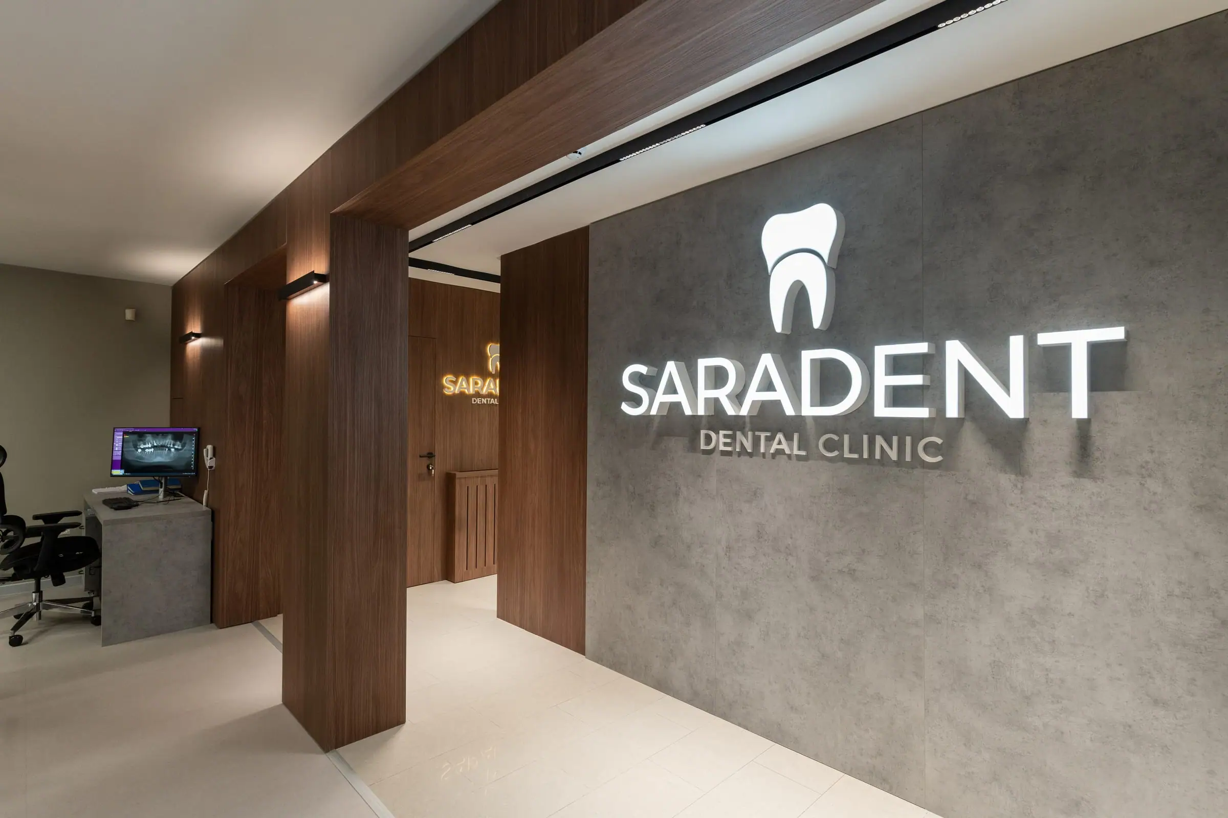 Natpis Saradent Dental Clinic na betonskom zidu u hodniku