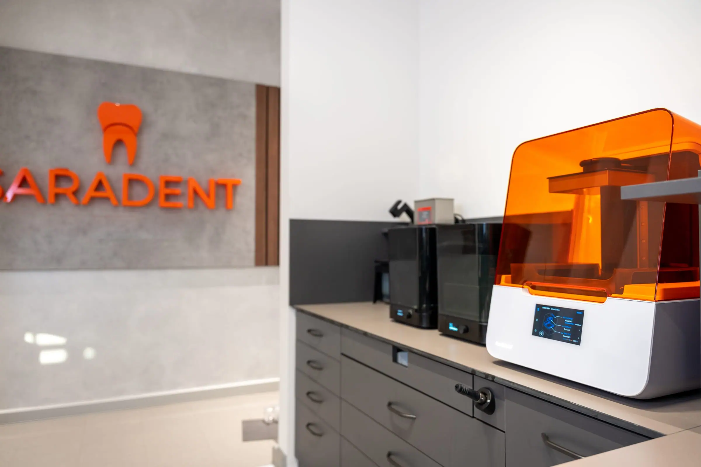 Natpis Saradent zubotehnika i 3D printer u laboratoriju